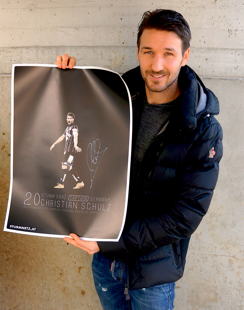 Christian Schulz hält sein signiertes Poster